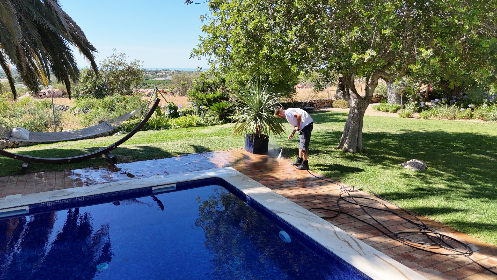 Whitehouse Services pressure washing a terracotta pool surround at a luxury villa in the Algarve Golden Triangle
