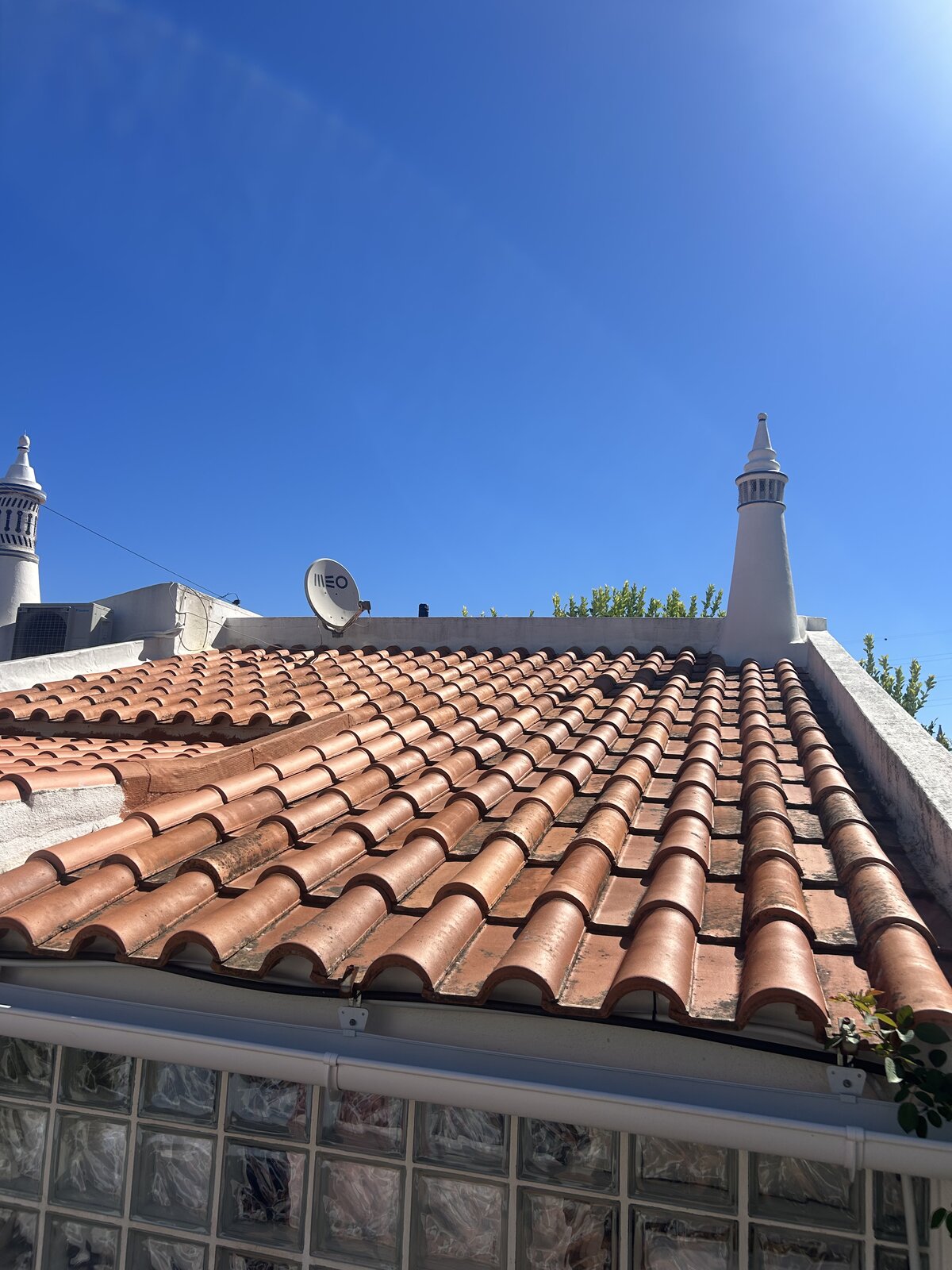 Algarve villa terracotta roof tiles dulled by moss and dirt before soft washing